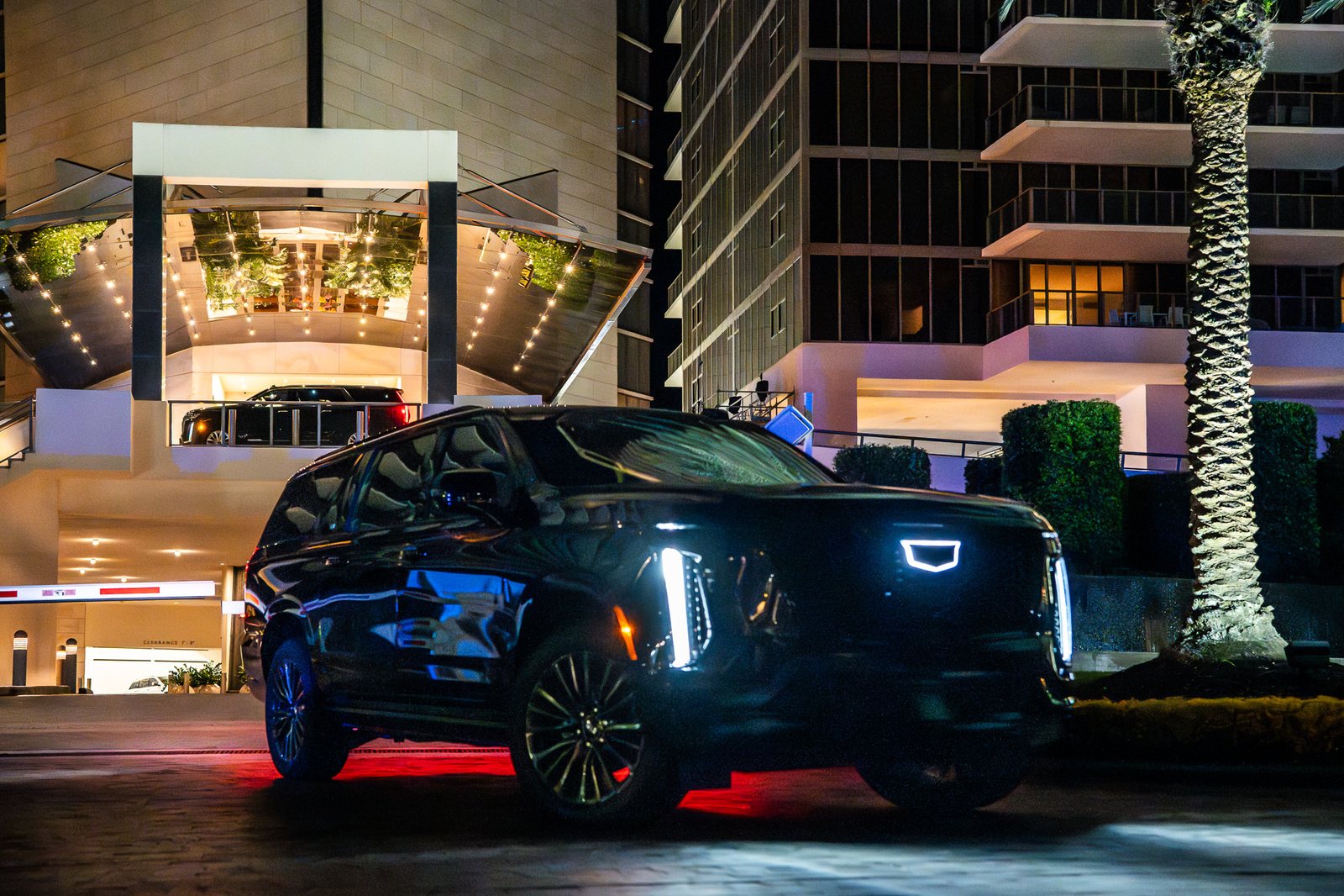 Black Cadillac Escalade chauffeur car at night in Miami