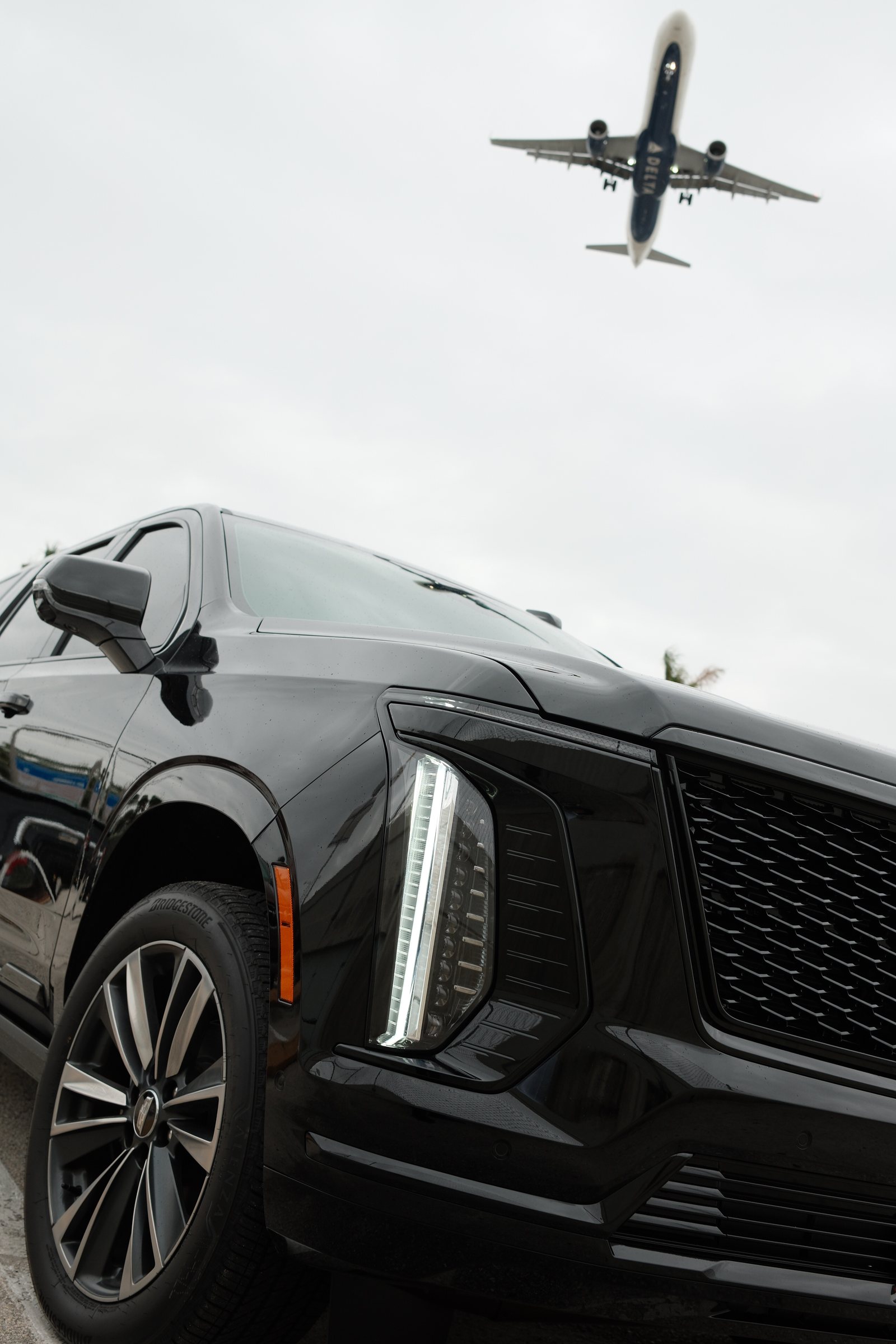 Самолёт над чёрным Cadillac Escalade